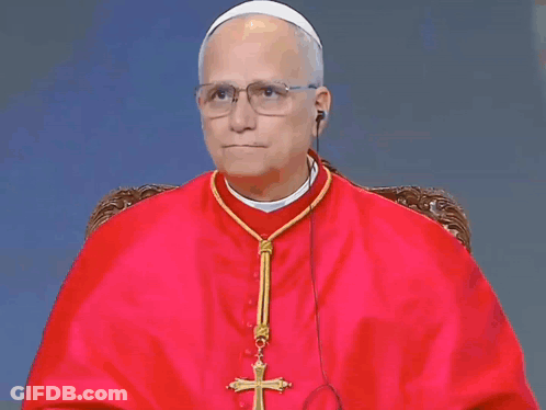 A Man In A Red Robe Has A Cross On His Neck GIF