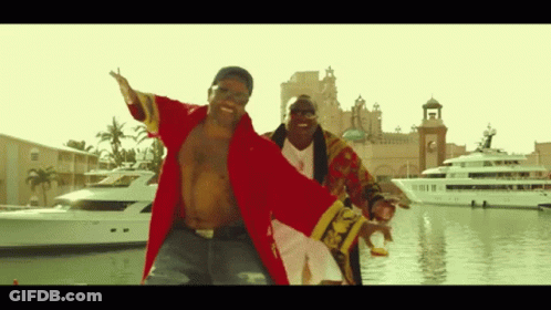 A Man In A Red Robe Is Dancing With Another Man In A Gold Robe GIF