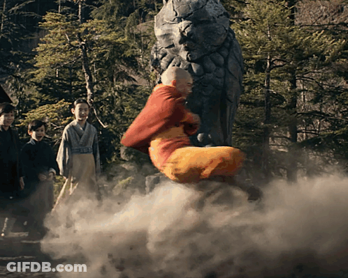 A Man In A Red Robe Is Flying Through The Air In Front Of A Statue GIF