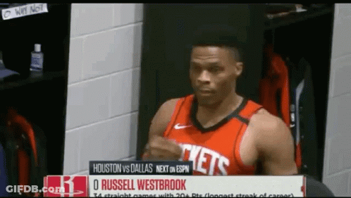 A Man In A Red Rockets Jersey Is Standing In A Locker Room GIF