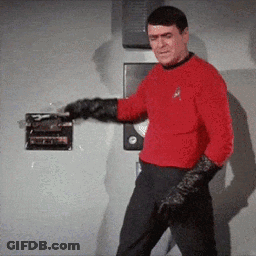 A Man In A Red Shirt And Black Gloves Is Standing In Front Of A Door GIF