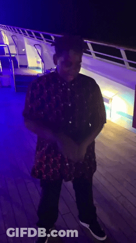 A Man In A Red Shirt And Black Pants Is Standing On A Deck GIF