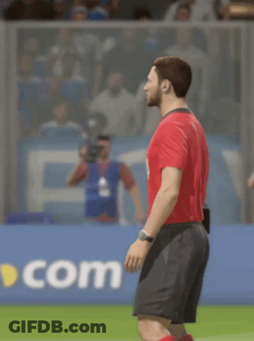 A Man In A Red Shirt And Black Shorts Is Standing On A Field GIF