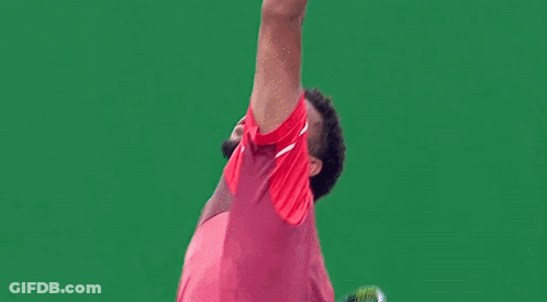 A Man In A Red Shirt And Shorts Is Playing Tennis GIF