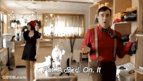 A Man In A Red Shirt And Suspenders Is Standing In A Room With A Woman In A Black Dress . GIF