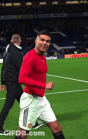 A Man In A Red Shirt And White Shorts Is Running On A Field GIF