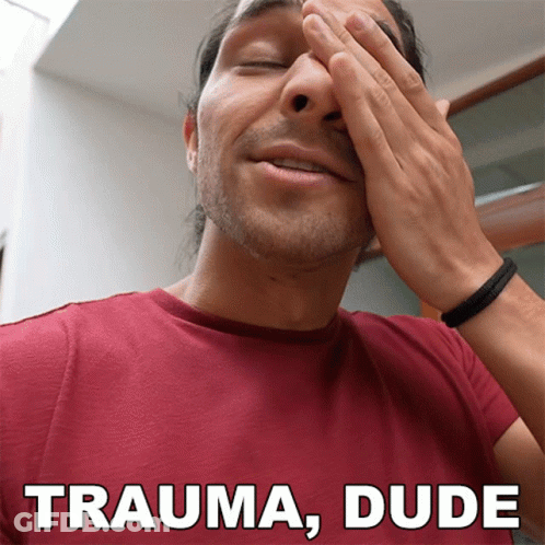 A Man In A Red Shirt Covering His Face With His Hands And The Words Trauma Dude Above Him GIF