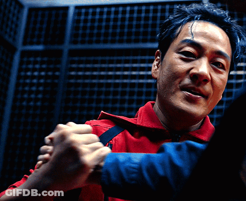 A Man In A Red Shirt Holds Another Man 'S Hand GIF