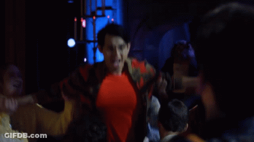 A Man In A Red Shirt Is Being Lifted By Another Man In A Yellow Jacket GIF