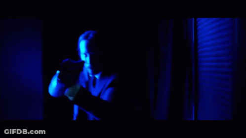 A Man In A Red Shirt Is Being Punched In The Face By Another Man In A Suit GIF