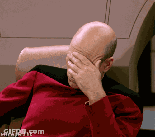 A Man In A Red Shirt Is Covering His Face With His Hands GIF