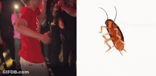 A Man In A Red Shirt Is Dancing In Front Of A Crowd Next To A Cockroach . GIF