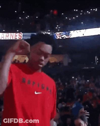 A Man In A Red Shirt Is Dancing In Front Of A Crowd With A Sign That Says Big GIF