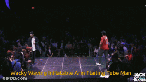 A Man In A Red Shirt Is Dancing In Front Of A Crowd With The Words Wacky Waving Inflatable Arm Flailing Tube Man Written GIF