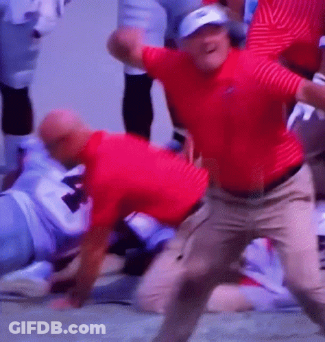 A Man In A Red Shirt Is Dancing In Front Of A Group Of People GIF
