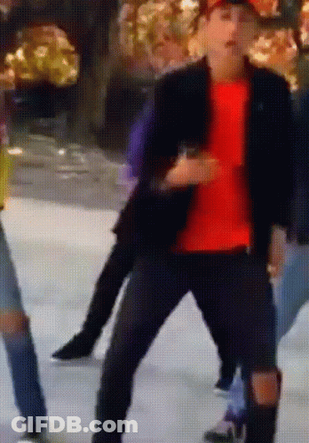 A Man In A Red Shirt Is Dancing On A Ice Rink GIF