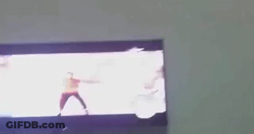 A Man In A Red Shirt Is Dancing On A Tv GIF