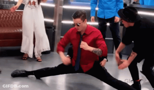 A Man In A Red Shirt Is Doing A Split GIF