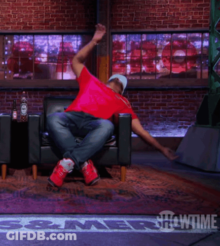 A Man In A Red Shirt Is Doing A Trick On A Showtime Stage GIF