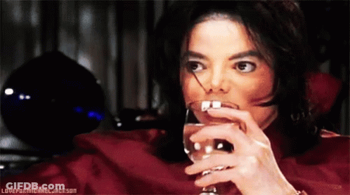 A Man In A Red Shirt Is Drinking From A Wine Glass With The Words Loveformichael Jackson Below Him GIF