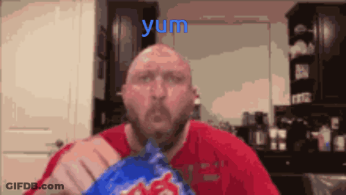 A Man In A Red Shirt Is Eating A Bag Of Potato Chips And The Word Yum Is Above Him GIF