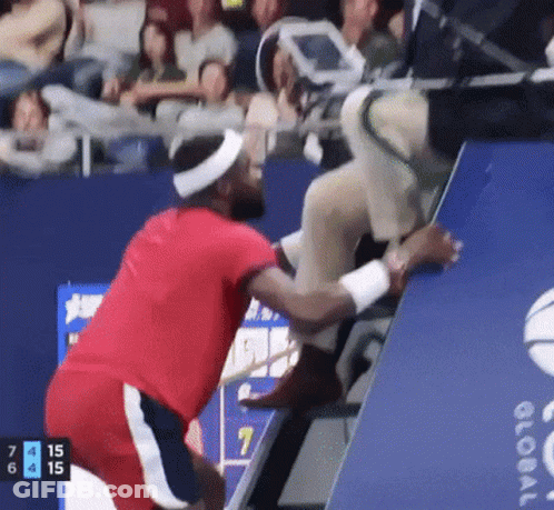 A Man In A Red Shirt Is Helping Another Man Up A Staircase GIF