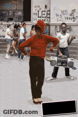A Man In A Red Shirt Is Holding A Boombox In Front Of A Building That Has Lee Written On It GIF
