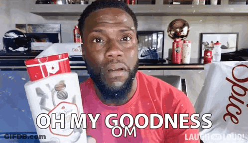 A Man In A Red Shirt Is Holding A Bottle Of Old Spice Deodorant GIF