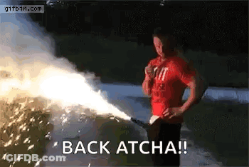 A Man In A Red Shirt Is Holding A Firework Display And Says `` Back Atcha '' . GIF