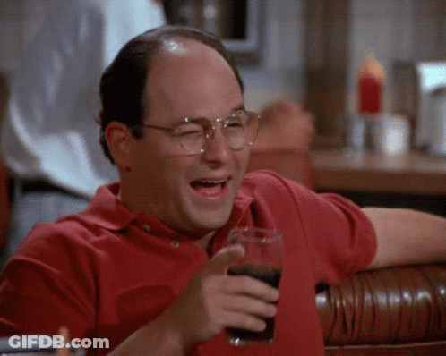 A Man In A Red Shirt Is Holding A Glass Of Soda And Laughing . GIF