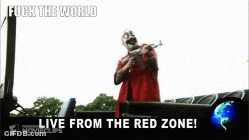 A Man In A Red Shirt Is Holding A Gun With The Words Fuck The World Live From The Red Zone GIF