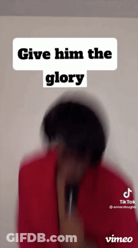 A Man In A Red Shirt Is Holding A Microphone And Says Give Him The Glory . GIF