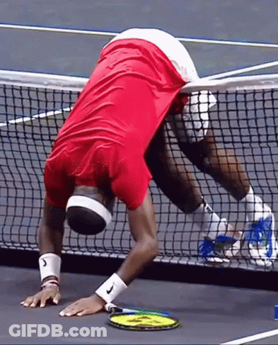 A Man In A Red Shirt Is Holding A Tennis Racquet On A Tennis Court .. GIF