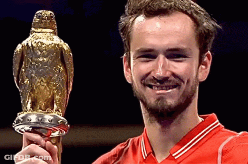 A Man In A Red Shirt Is Holding A Trophy GIF