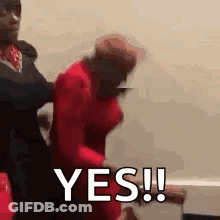 A Man In A Red Shirt Is Holding A Woman In A Red Dress And Says Yes . GIF