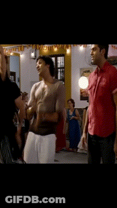 A Man In A Red Shirt Is Holding A Woman In A Room GIF