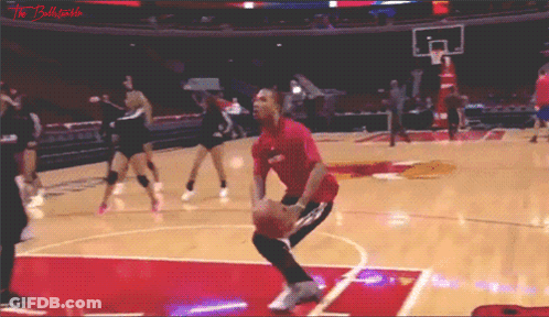 A Man In A Red Shirt Is Jumping For A Basketball GIF