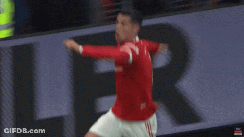 A Man In A Red Shirt Is Jumping In The Air While Playing Soccer . GIF