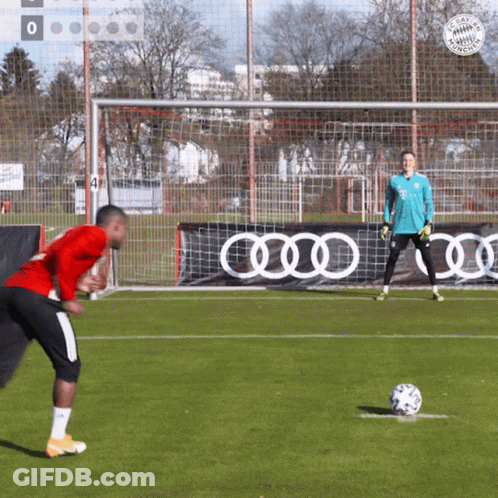 A Man In A Red Shirt Is Kicking A Soccer Ball GIF