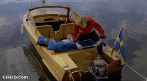 A Man In A Red Shirt Is Kneeling On A Yellow Boat GIF