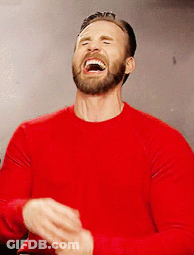 A Man In A Red Shirt Is Laughing With His Mouth Open GIF