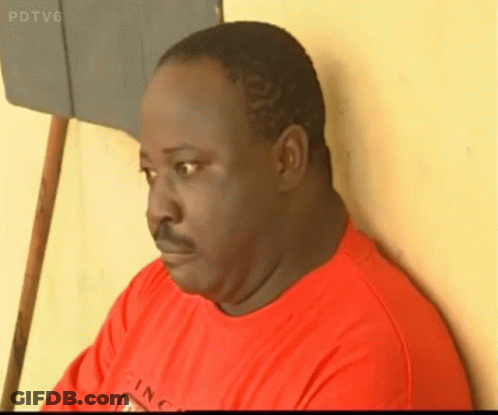 A Man In A Red Shirt Is Leaning Against A Wall With Pdtv6 On The Bottom Right GIF