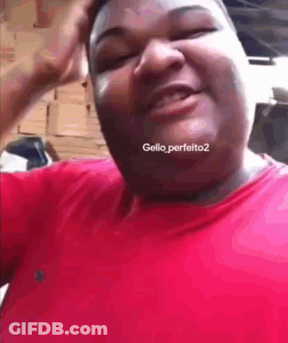 A Man In A Red Shirt Is Making A Funny Face And Has The Hashtag Gellio_perfeito2 On His Neck GIF
