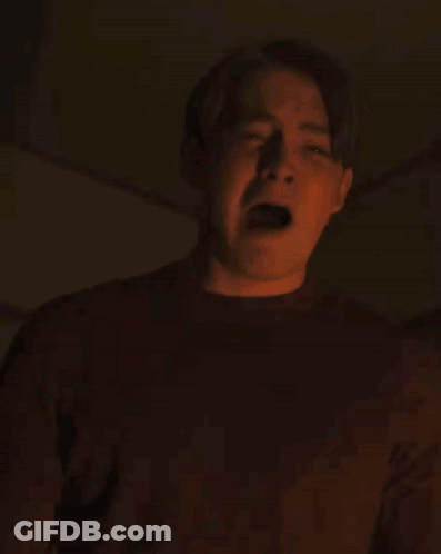 A Man In A Red Shirt Is Making A Funny Face With His Mouth Open GIF