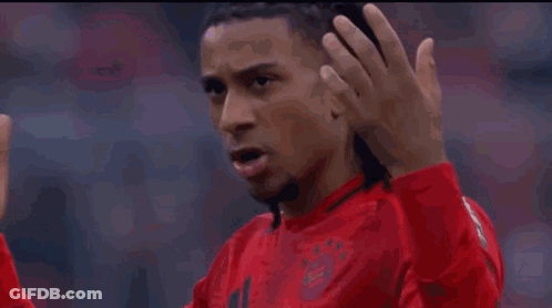 A Man In A Red Shirt Is Making A Gesture With His Finger GIF