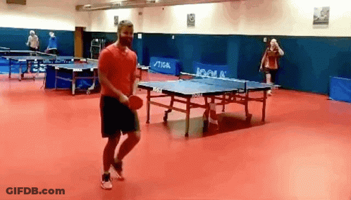 A Man In A Red Shirt Is Playing Ping Pong In A Room With Ping Pong Tables By Joola GIF