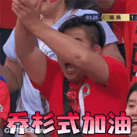 A Man In A Red Shirt Is Raising His Arms In The Air In A Crowd Of People . GIF