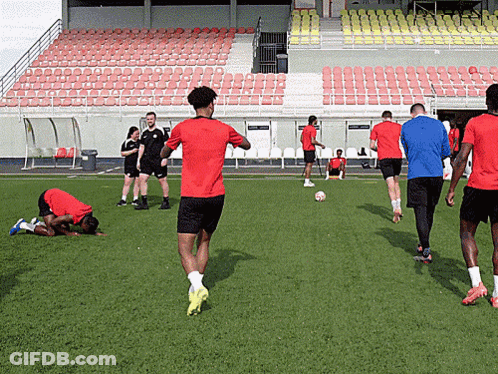 A Man In A Red Shirt Is Running On A Field GIF