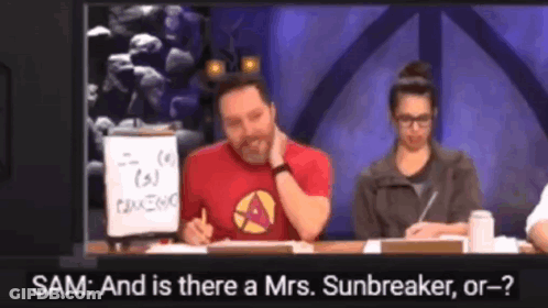 A Man In A Red Shirt Is Sitting At A Table Talking To A Woman In A Grey Jacket GIF