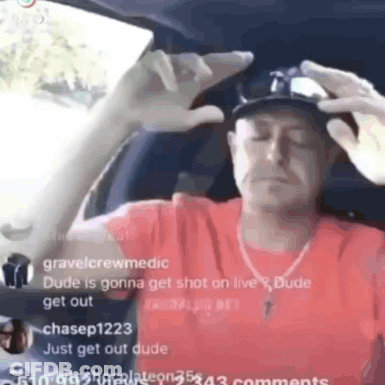 A Man In A Red Shirt Is Sitting In A Car With His Eyes Closed And A Hat On . GIF